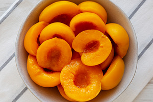 Healthy Organic Canned Peach Halves in a Bowl, top view., a Food & Drink Photo by LiudmylaChuhunova