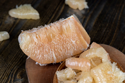 Freshly peeled pink pomelo on the table, a Photo by MyPhotos