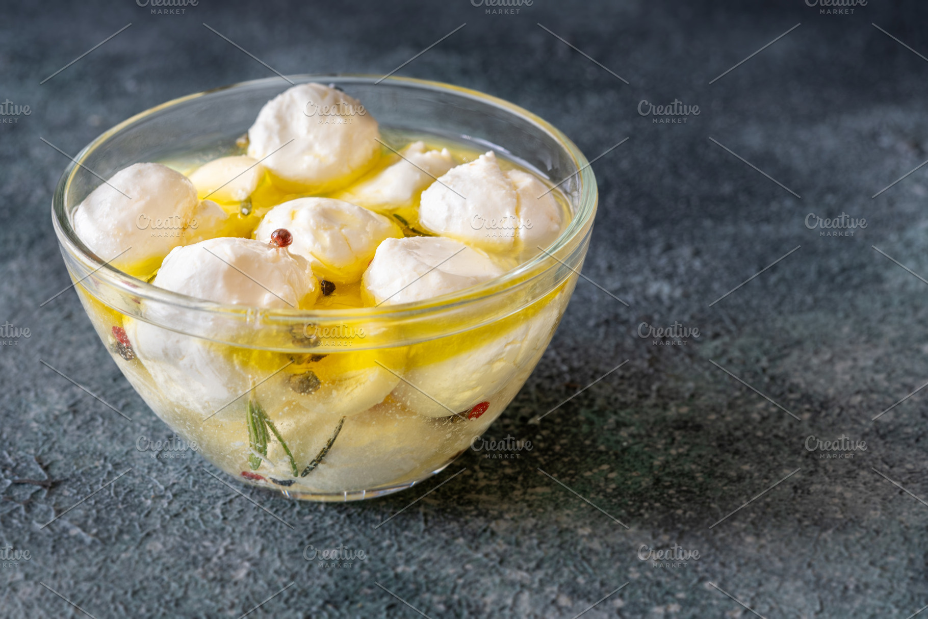 Glass bowl of labneh balls in oil, a Food & Drink Photo by Alexander Prokopenko