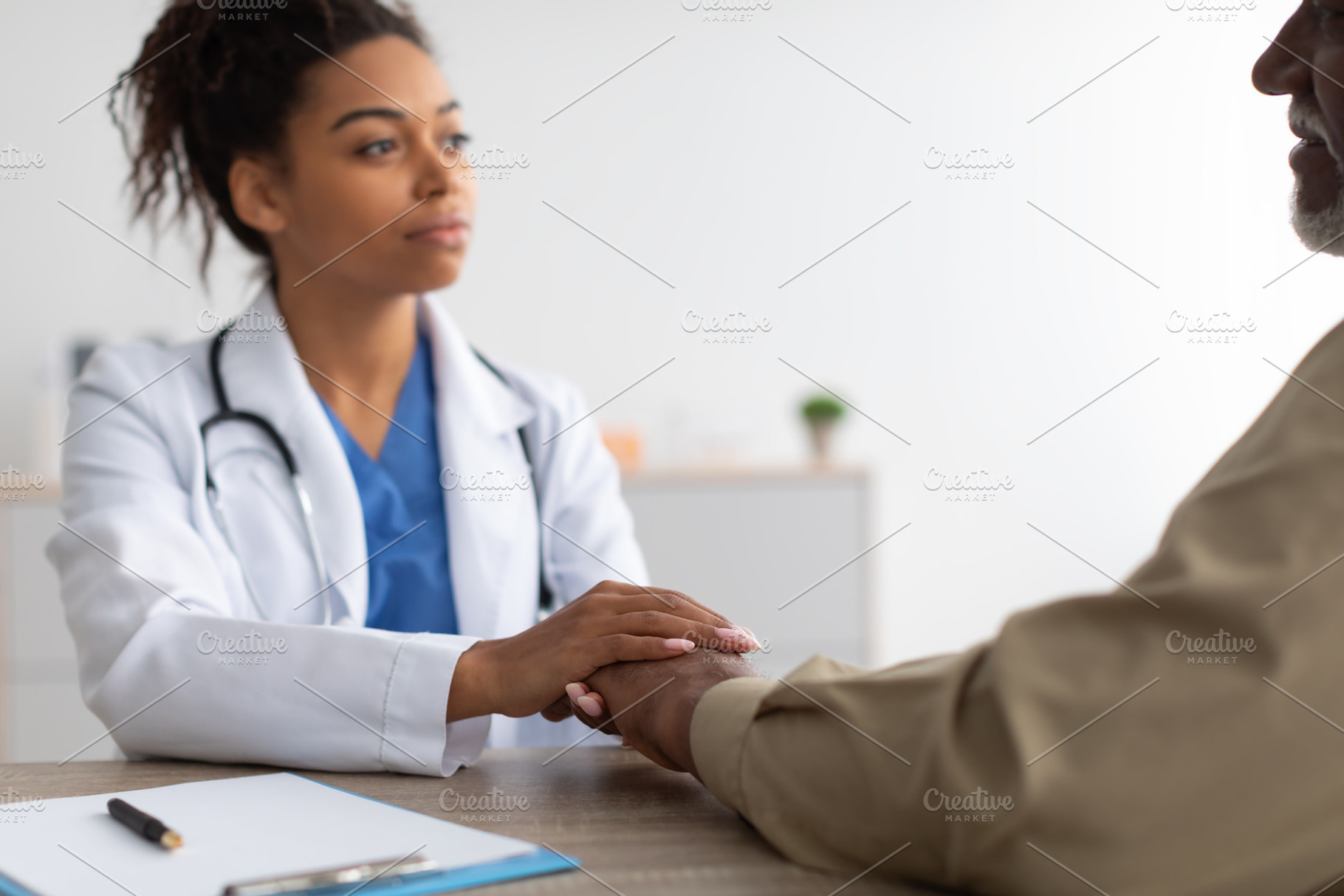 Close up of black female doctor holding male patient's hands, a Photo by Prostock-Studio