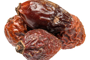 A small pile of dried rose hips with wrinkled skin texture