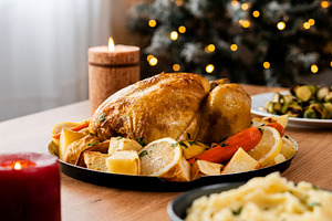 Whole roasted chicken with potatoes and vegetables.