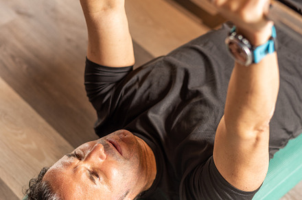 Cropped view of an adult man doing bench press on step in gym, a Sports & Recreation Photo by Iván Moreno STOCK PHOTO