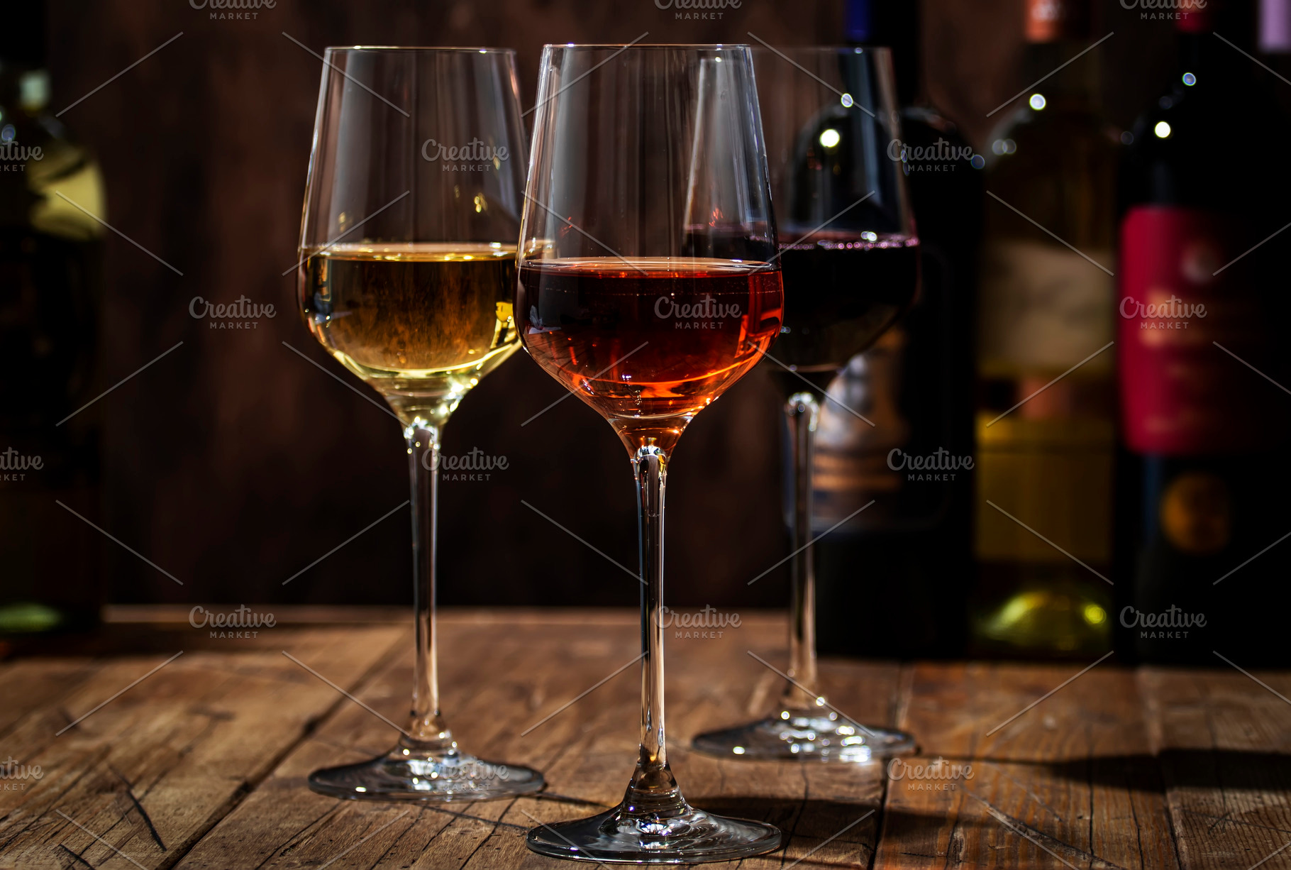 Red, white and rose wine in glasses on wooden background and col, a Food & Drink Photo by 5PH