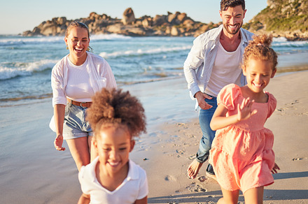 Beach, summer and travel with family running on sand in Mexico for vacation fun with kids. Happy mother and father bond together chasing excited children on ocean holiday break in the sun., a Photo by Peopleimages.com