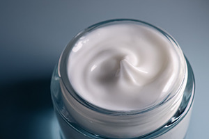 White face cream in a blue jar, symbolizing beauty, skincare, hydration, and co, a Photo by Studio ANNA