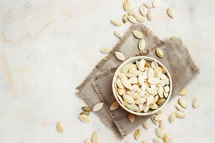 Pumpkin seeds in bowl isolated on white background containing pumpkin, seed