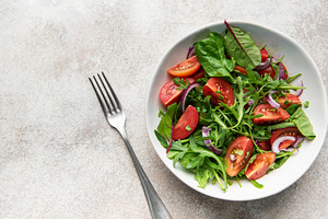 Fresh green salad with tomatoes and red onion, a Food & Drink Photo by Olena Rudo