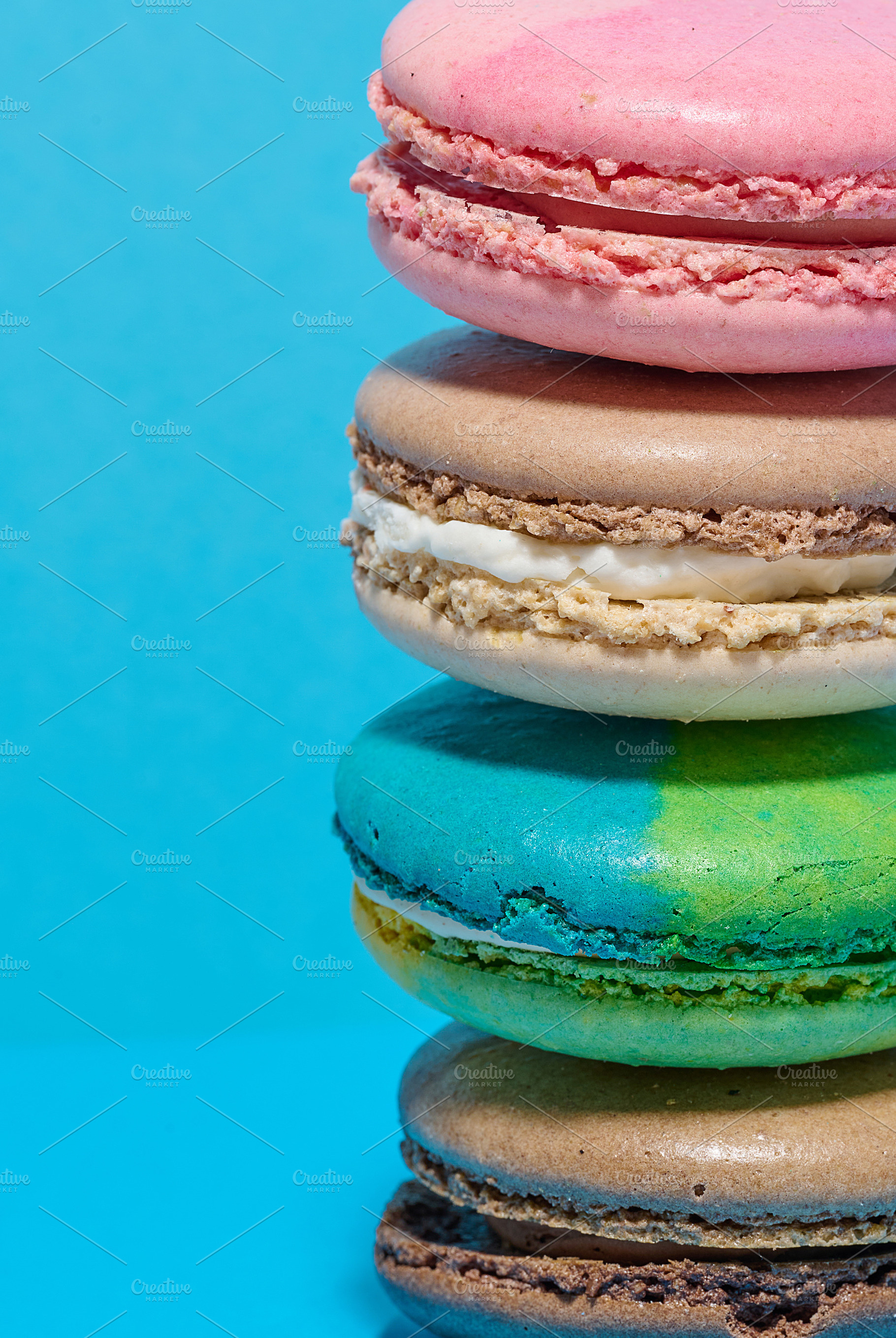 Multicolored macarons on a blue background, a Food & Drink Photo by ndanko