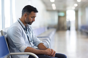 Worried man sits alone in hospital w, a Photo by Iftikhar Alam