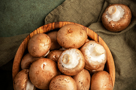 Fresh brown champignon mushrooms in wooden bowl, green stone kit, a Food & Drink Photo by 5PH