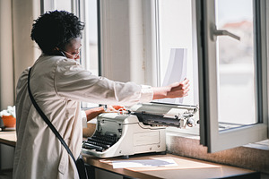 Loading Paper in Typewriter, a Person Photo by SkyNext