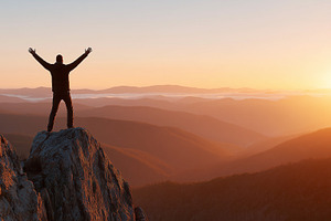 Man standing on top of a mountain, a Person Photo by MistyDay