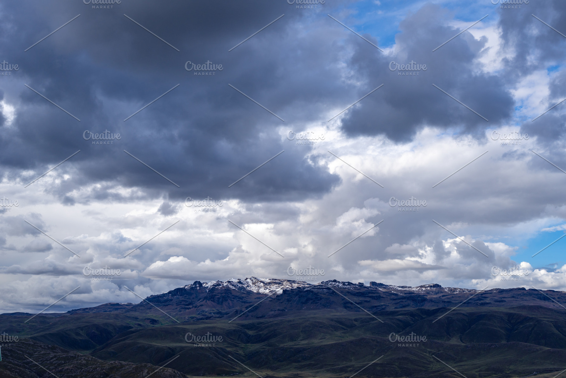 Snow-capped mountain under dark storm clouds in the Peruvian hig, a Nature Photo by GoodGoods