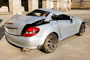 Severely Damaged Silver Sports Car Displayed in a Public Square,, a Transportation Photo by Bepslabor