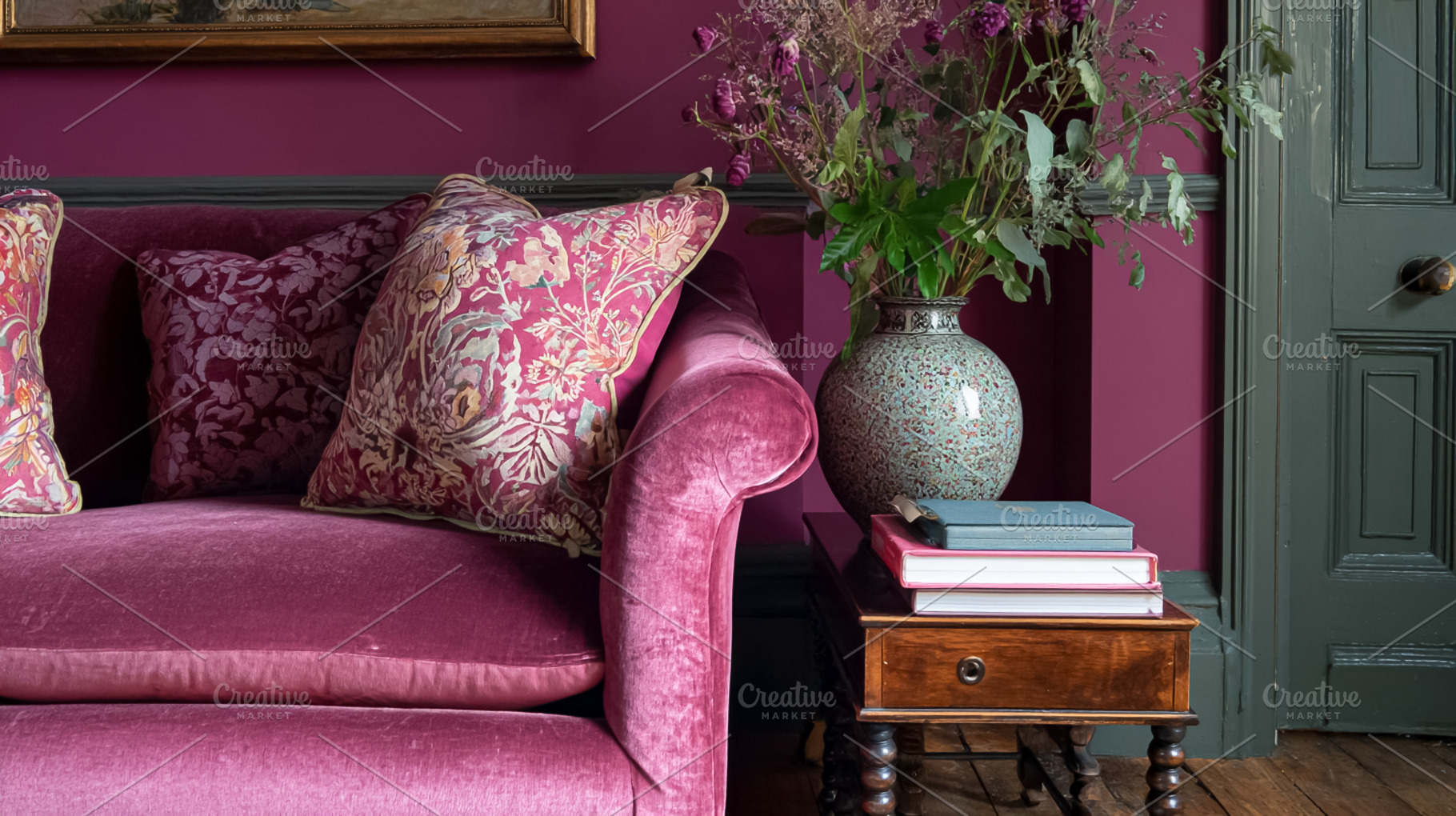 Velvet sofa with patterned cushions, vase of dried flowers, and, a Photo by Studio ANNA