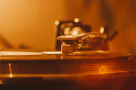 Close up of turntable needle on a vi featuring 70s, 80s, and album