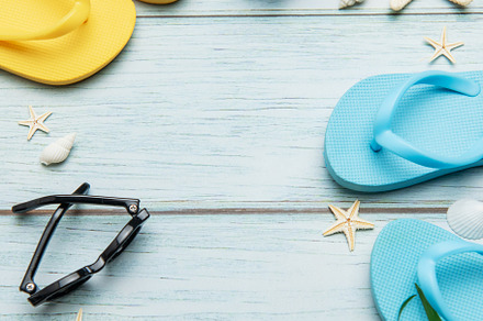 Summer accessories arranged on blue wooden planks create the per