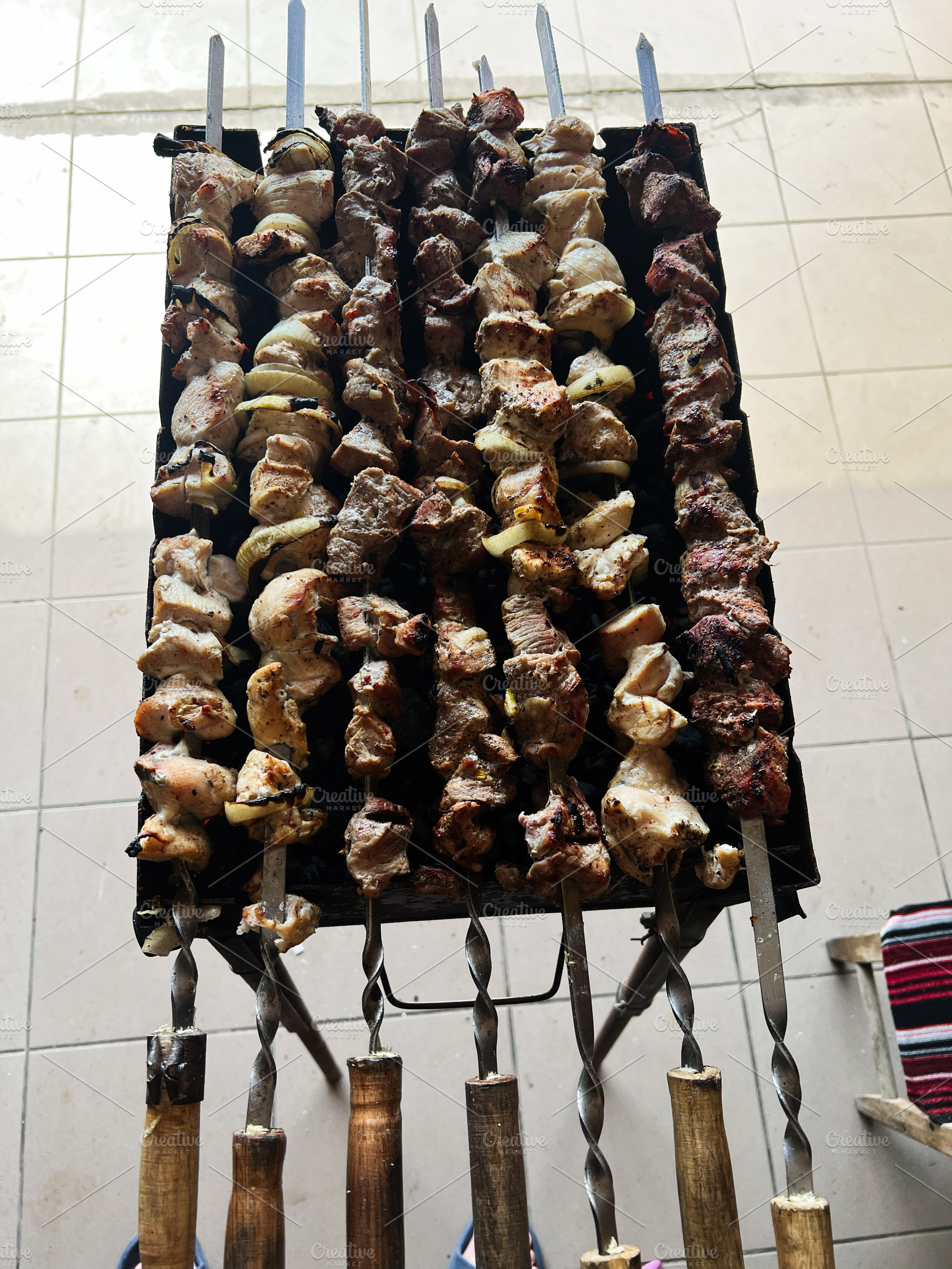 Grilled meat skewers arranged neatly on skewers over a hot barbecue grill, a Photo by AS photostudio