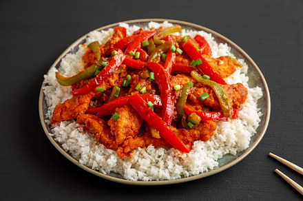Homemade Simple Chili Chicken with White Rice on a Plate on a bl, a Food & Drink Photo by LiudmylaChuhunova