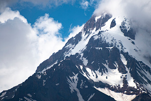 High snow peak of Mount Kazbek against blue sky and clouds in Ge, a Photo by Pictures for you!!!!!!!!!