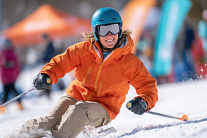 Woman skiing joyfully on snowy slope, a Sports & Recreation Photo by AlyaAnd