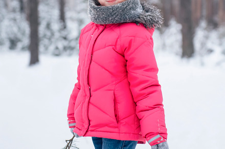 Little girl in a bright jacket plays in the winter forest, a Holiday Photo by Olena Rudo