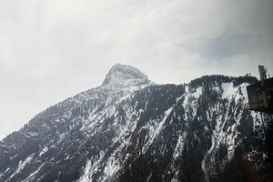 Snow-covered mountain under a cloudy sky in a picturesque winter setting Switze, a Photo by AS photostudio