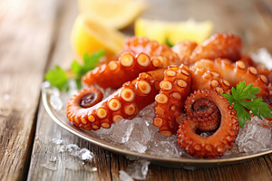 Fresh octopus on ice with lemon and parsley, a Food & Drink Photo by AlyaAnd
