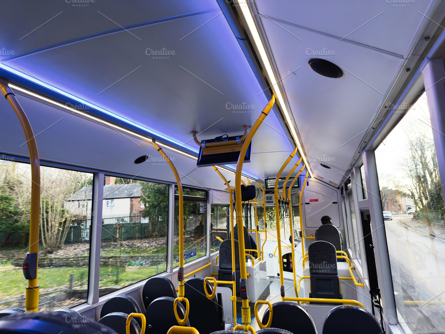 Interior of a modern Manchester bus with yellow poles and blue lighting during, a Photo by AS photostudio