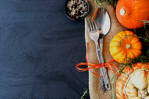 Seasonal wooden table setting with small pumpkins containing table