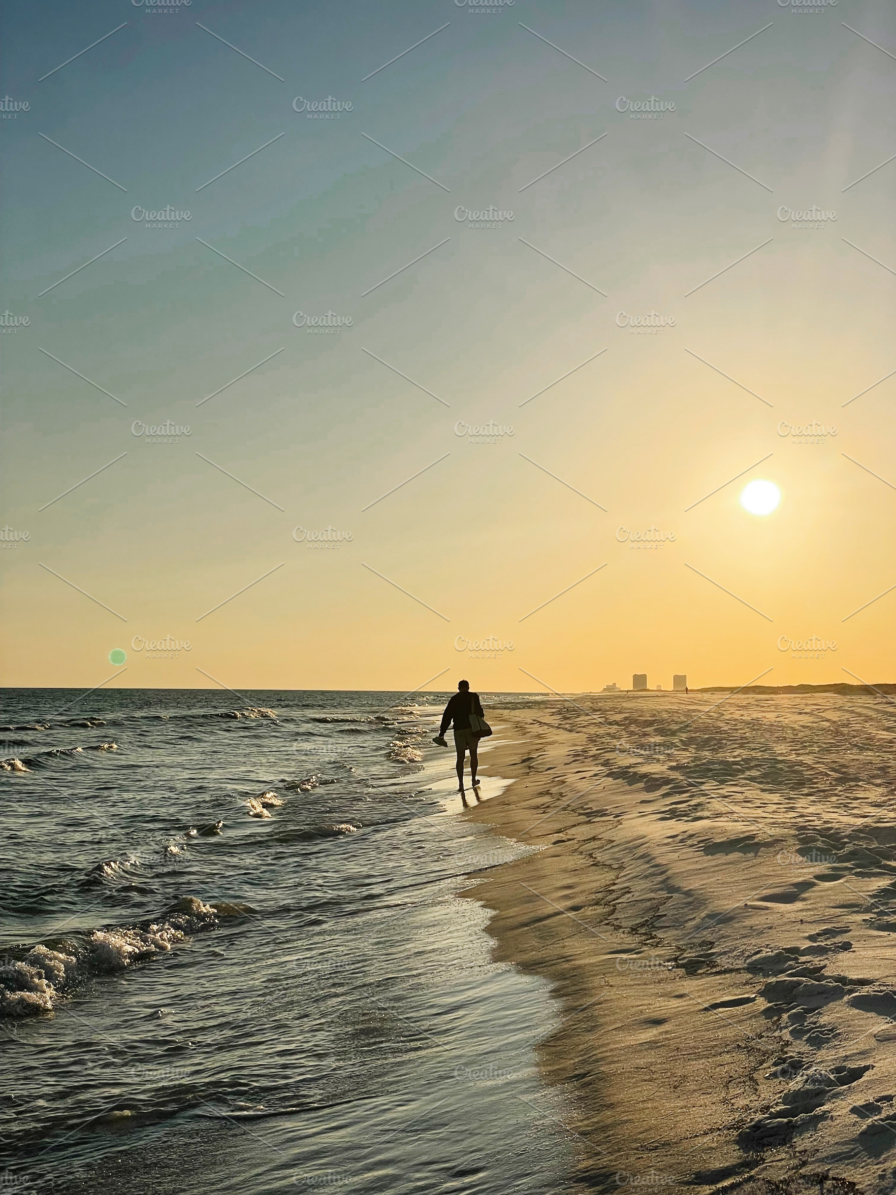 Silhouette of a person walking along a Florida Pensacola Beach at sunset with a, a Nature Photo by AS photostudio