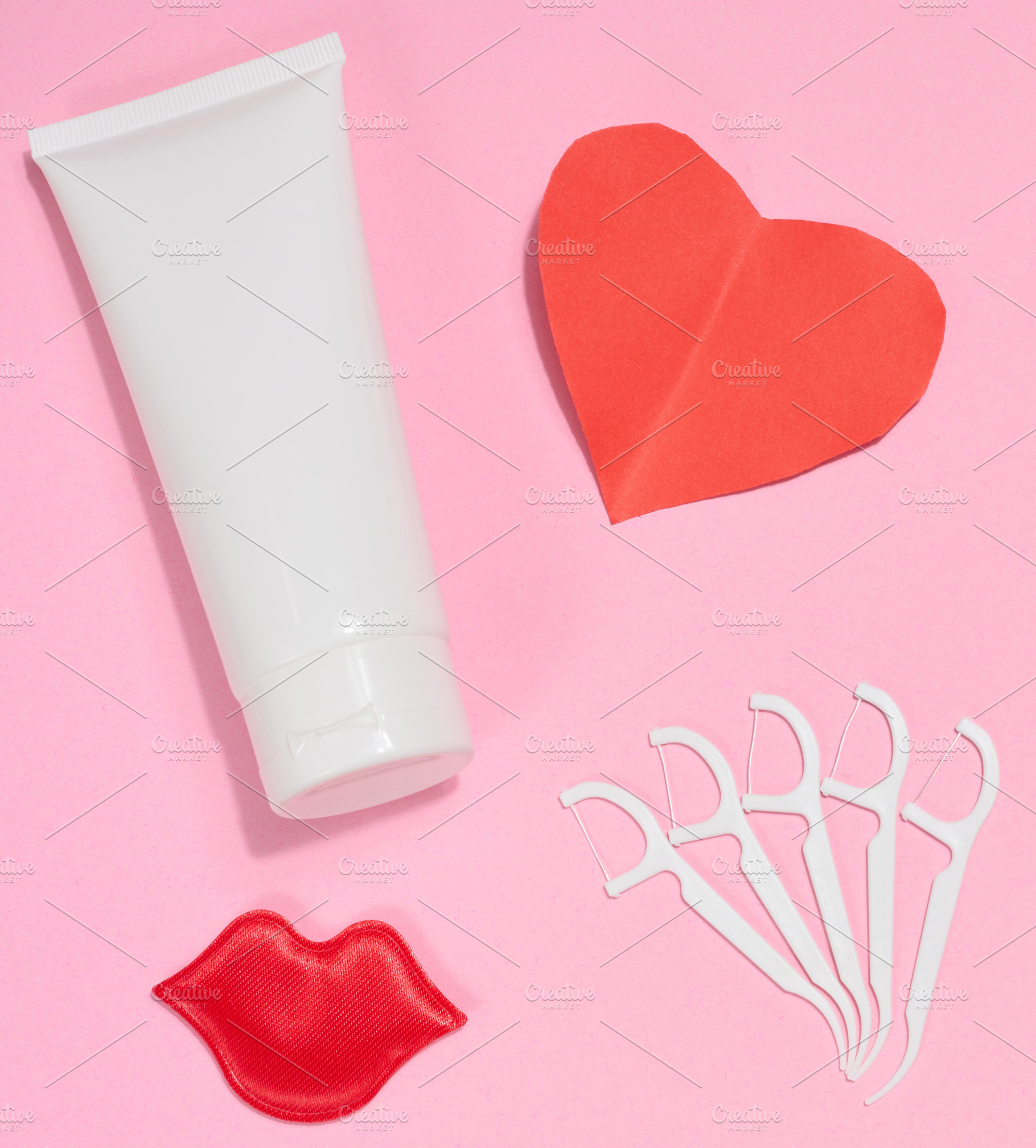 White tube of toothpaste, red paper heart, red decorative lips a, a Health & Medical Photo by ndanko