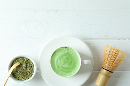 Matcha latte and accessories for making on white wooden table, a Food & Drink Photo by AtlasStudio PRO