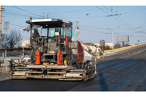 Modern asphalt paver machine working, an Industrial Photo by volodymyrshtun13795