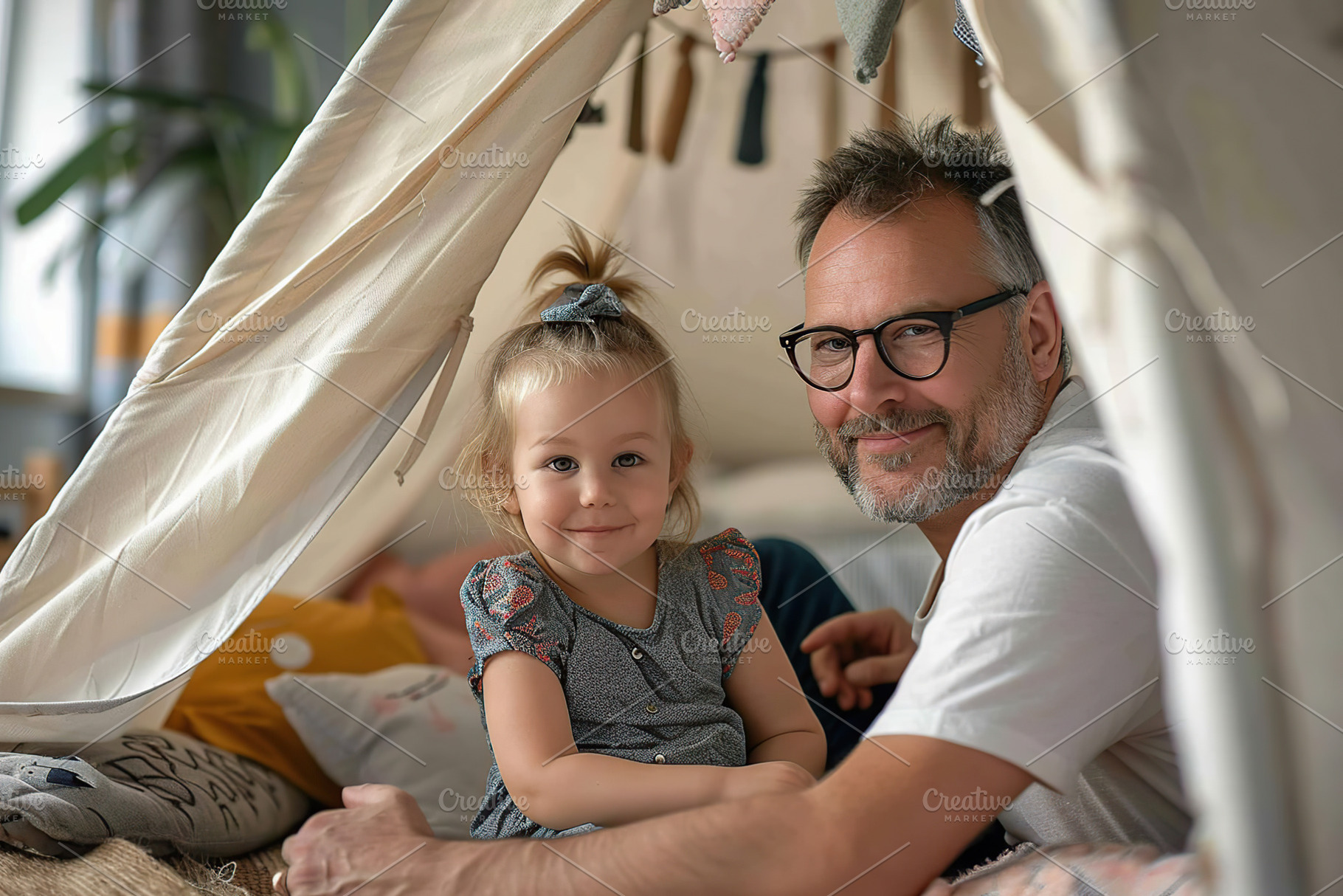 Cute little girl with her father playing in wigwam at home, a Person Photo by AlyaAnd