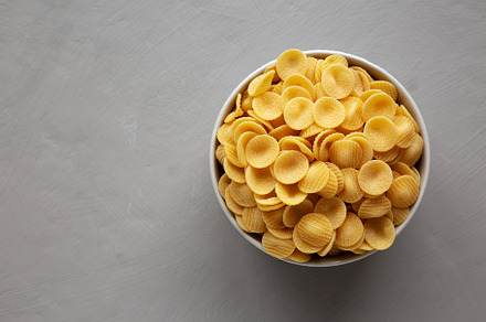 Dry, Uncooked Orecchiette Pasta in a Bowl, top view. Flat lay, o, a Food & Drink Photo by LiudmylaChuhunova