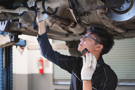 Asian male mechanical hold and shining flashlight to examine car, an Industrial Photo by Ministocker