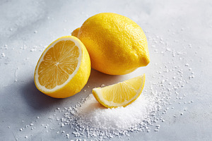 Fresh lemon with slice and salt on grey background, a Food & Drink Photo by AlyaAnd