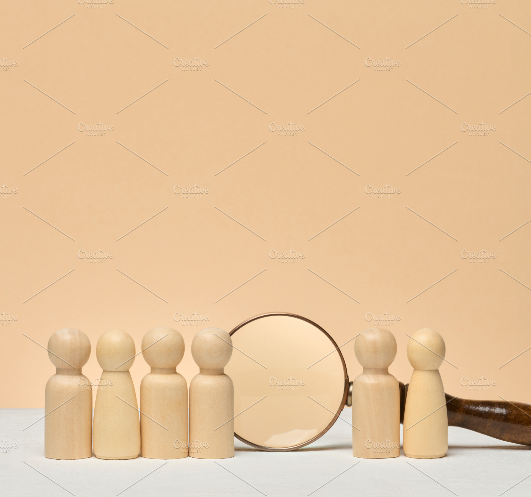A row of wooden human figures stands on a light surface, and a m, a Business Photo by ndanko