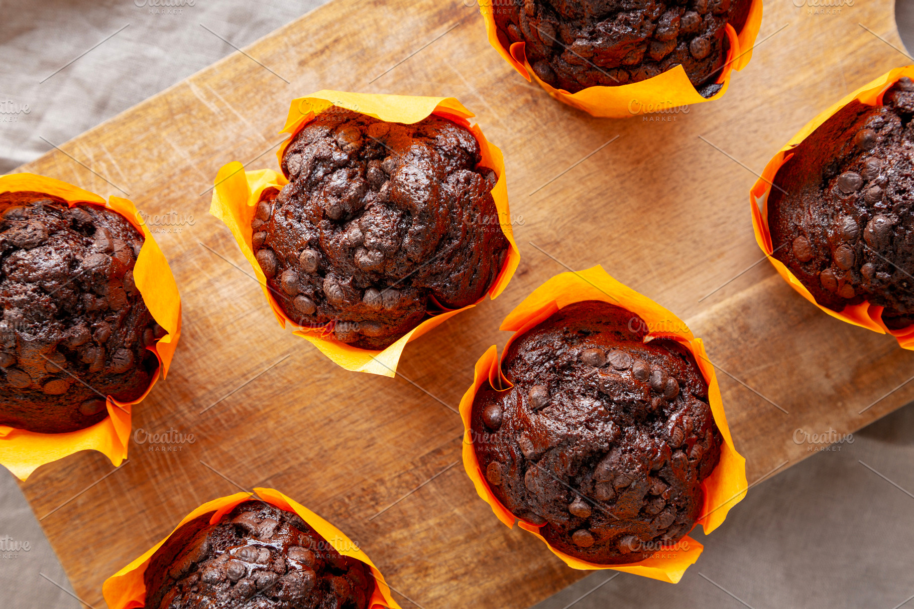 Homemade Chocolate Chip Muffins on a wooden board, top view., a Food & Drink Photo by LiudmylaChuhunova