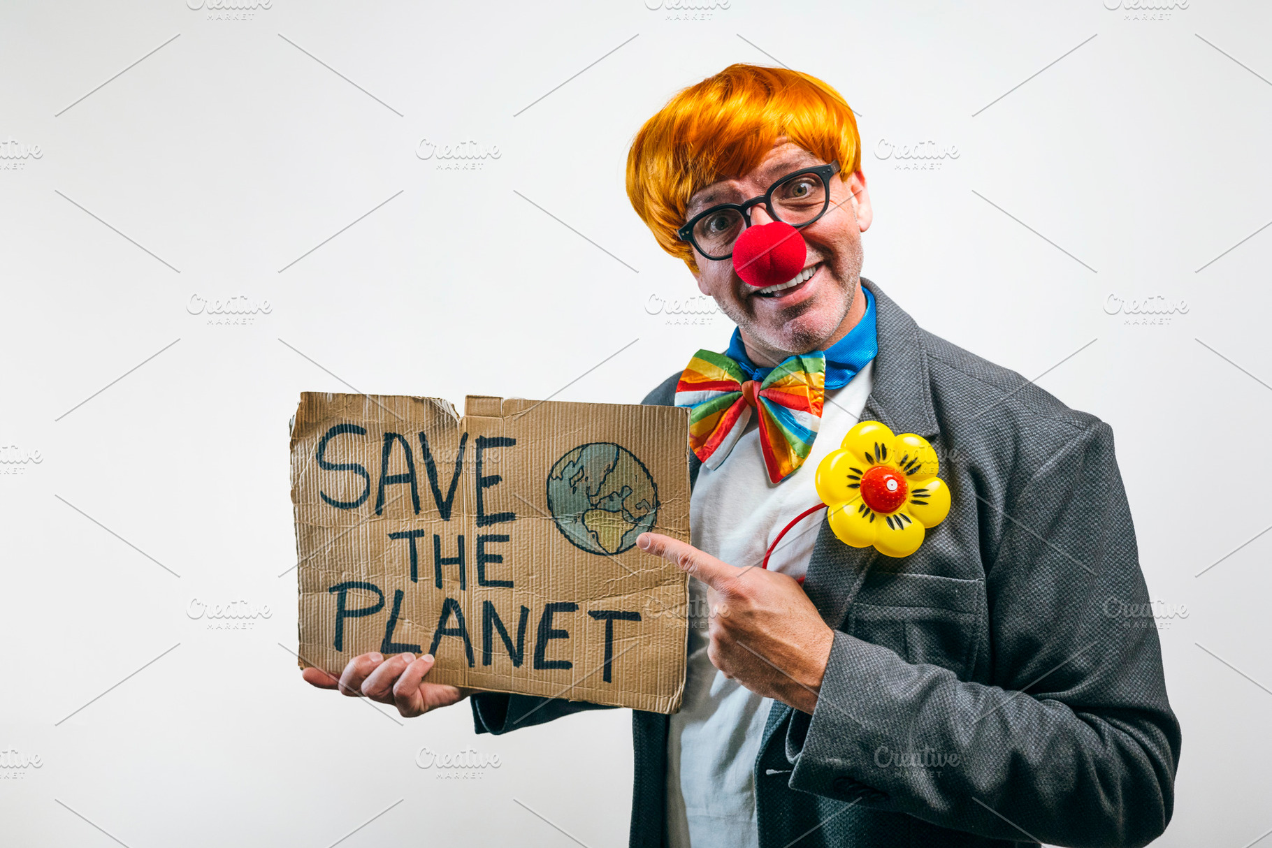 Clown holding save the planet sign advocating environmental awareness, a Person Photo by karrastock