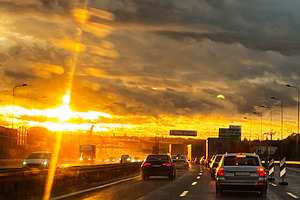 Golden Hour Highway Sunset with Busy Traffic and Wet Road Reflections, a Photo by AS photostudio