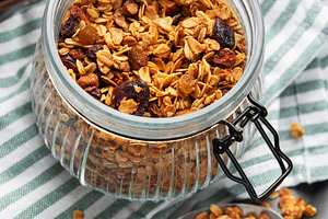 Healthy homemade granola breakfast cereal in glass jar, a Food & Drink Photo by Olena Rudo