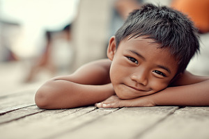 Smiling young boy lying on wooden, a Person Photo by MistyDay