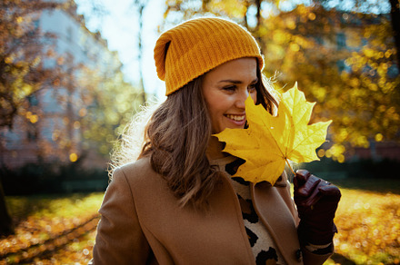 smiling modern female in brown coat and yellow hat, a Person Photo by Alliance Images