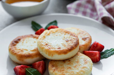 Cottage cheese pancakes, ricotta fritters on ceramic plate with, a Food & Drink Photo by Olena Rudo
