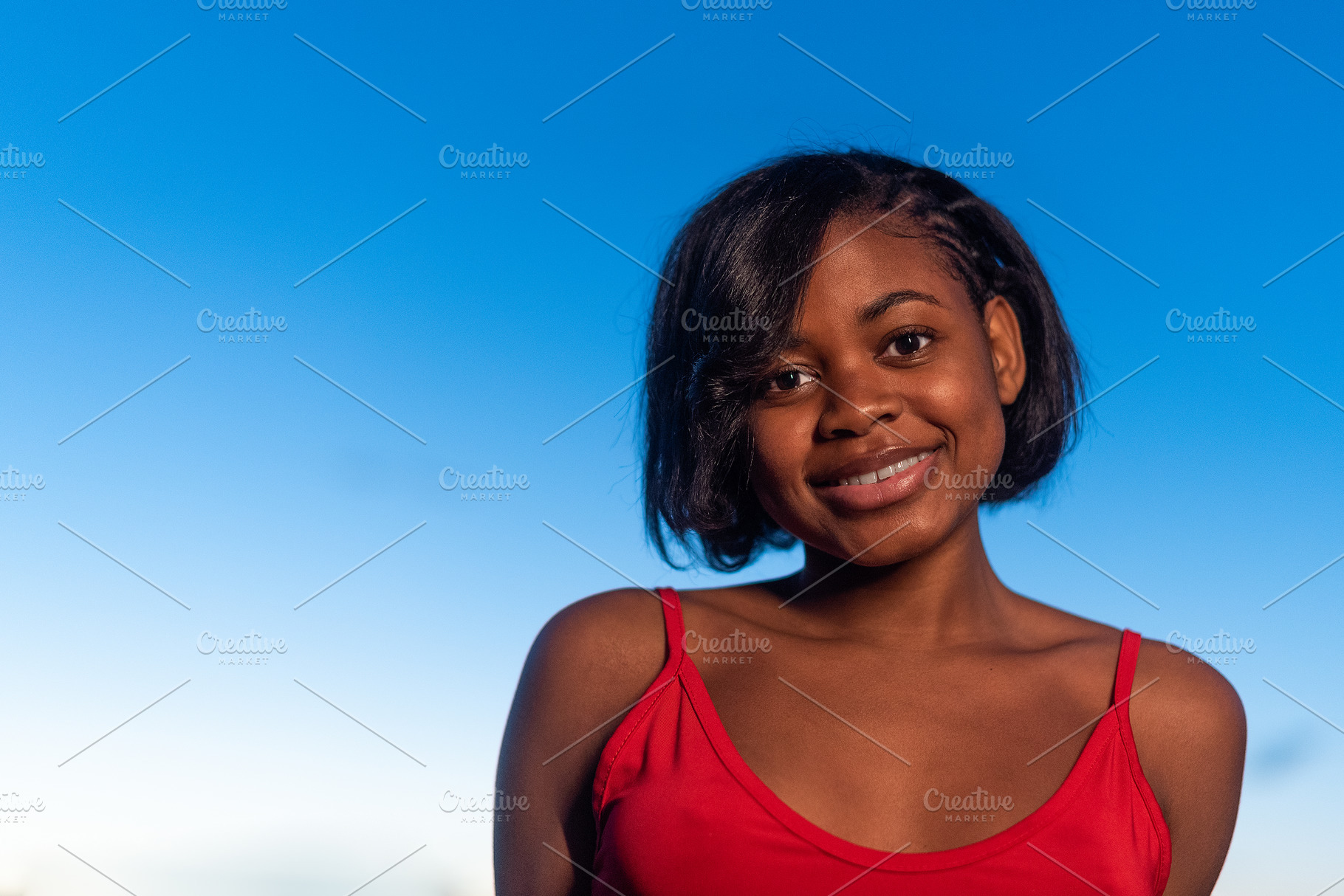 portrait of a young african woman smiling to the camera, a Person Photo by Iván Moreno STOCK PHOTO