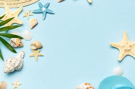 Summer accessories creating frame on light blue background with