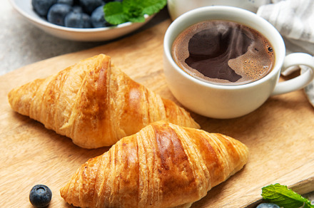 Delicious french croissants with coffee, honey and fresh blueber